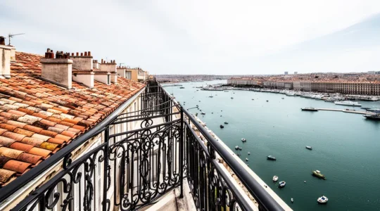 Vue aérienne d'un appartement marseillais avec terrasse donnant sur le Vieux-Port, sous un ciel bleu méditerranéen
