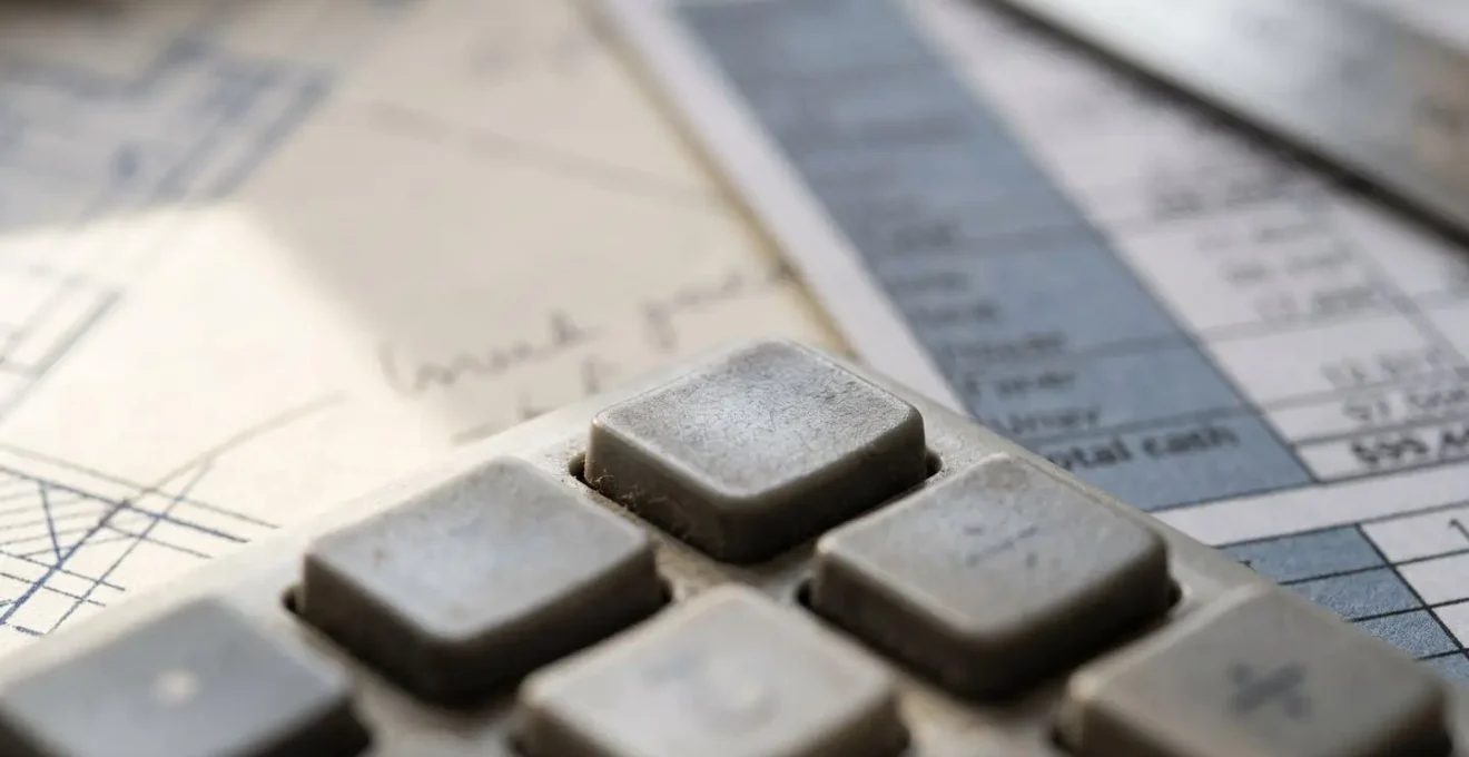Vue macro de documents financiers avec calculatrice et plans de rénovation