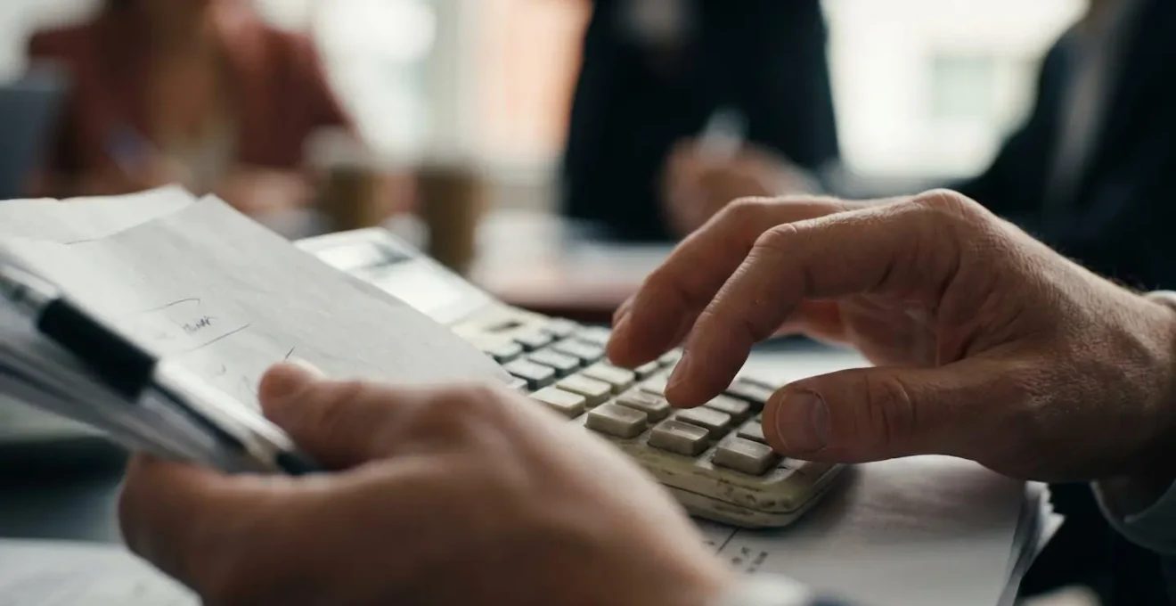 Groupe de copropriétaires analysant des documents financiers lors d'une assemblée générale